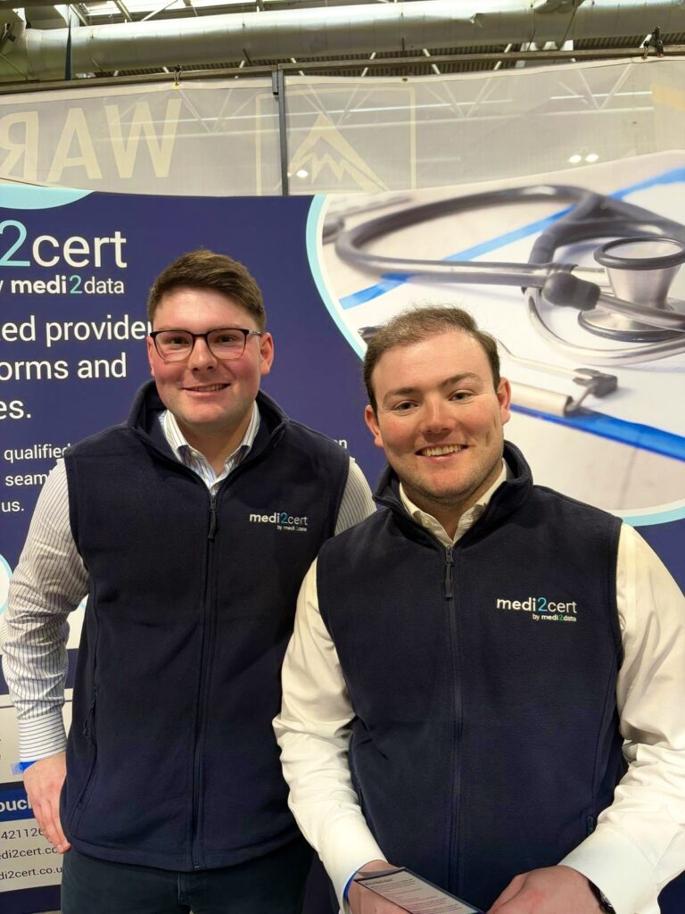 Nick and Vince standing on the Medi2cert stand, in front of our banner.