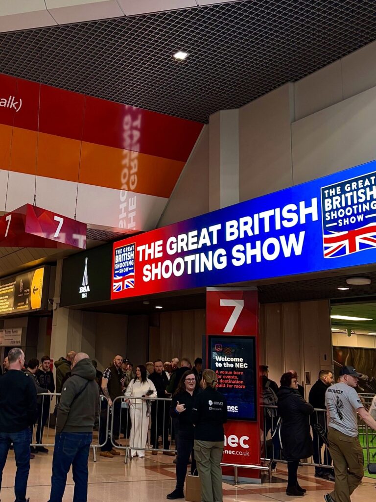 Outside the British Shooting Show hall at the Birmingham NEC. The focal point of the image is the main sign directing attendees into the hall.